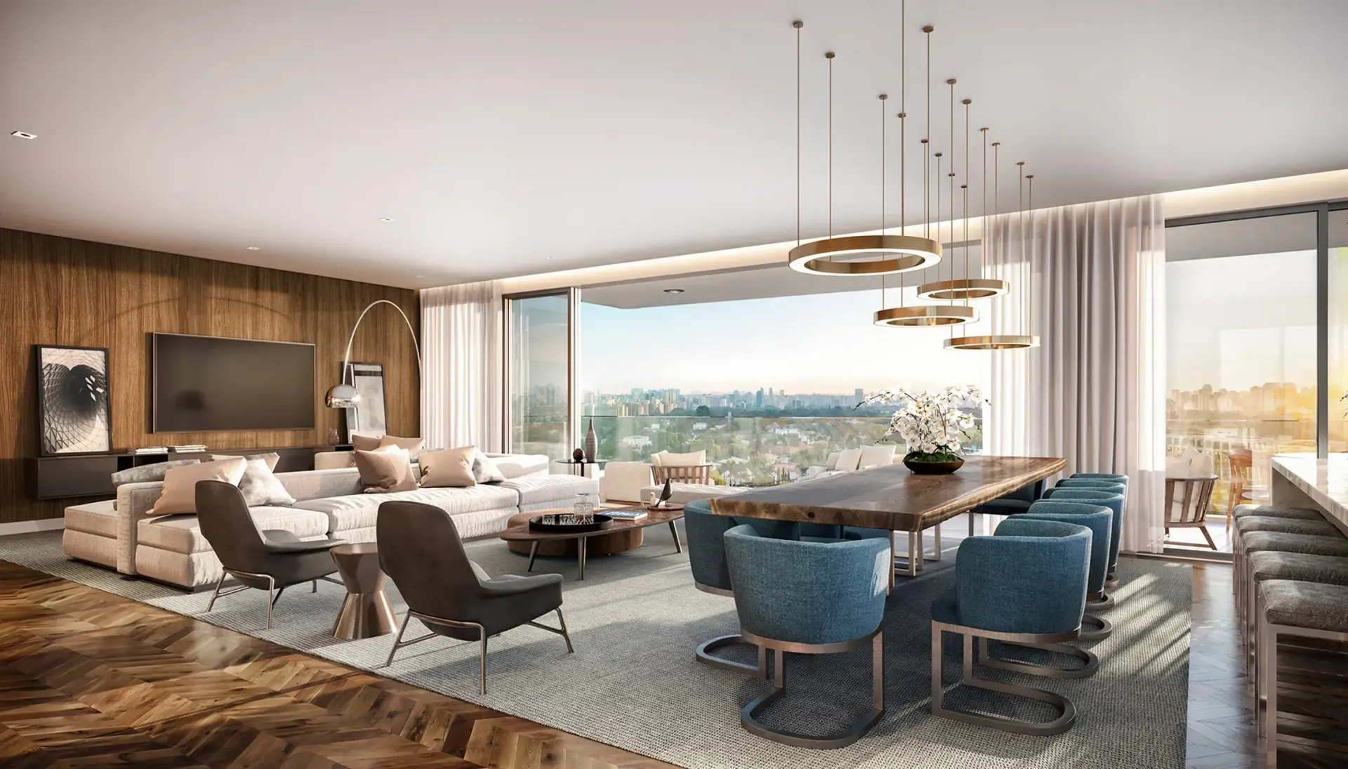 O living mobiliado: o sofá claro em L, a mesa de jantar de madeira com cadeiras azuis, os pendentes redondos, a parede de madeira com a televisão e a janela larga para as árvores.