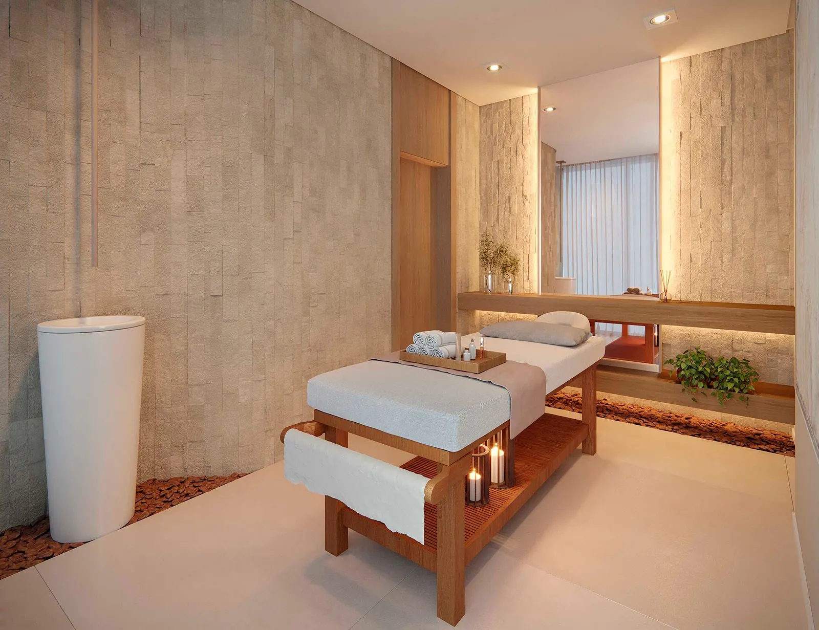 A sala de massagem, com a maca de madeira, um lavatório de pedra e luz baixa nas paredes.