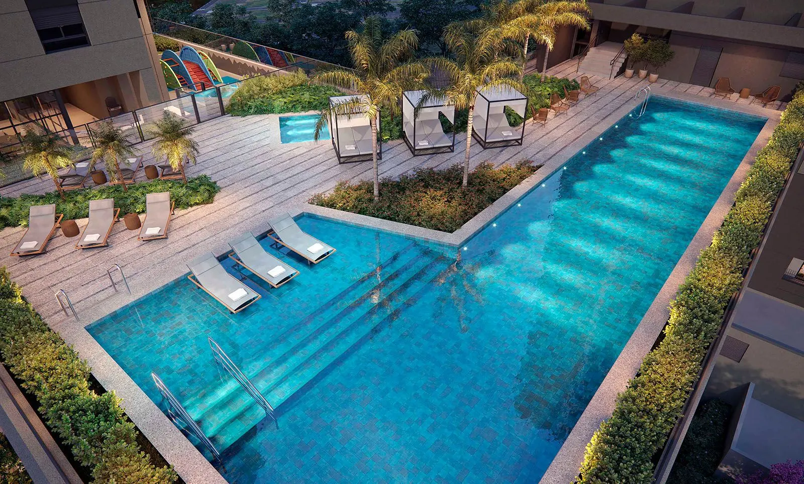 A piscina de 25 metros vista do alto, com espreguiçadeiras na água rasa, o solário com cabanas e o jardim tropical em volta.