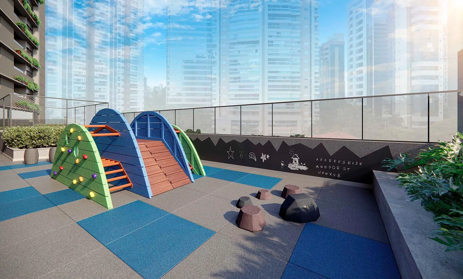 O playground ao ar livre, com estruturas de escalar coloridas sobre piso emborrachado azul e a cidade ao fundo.