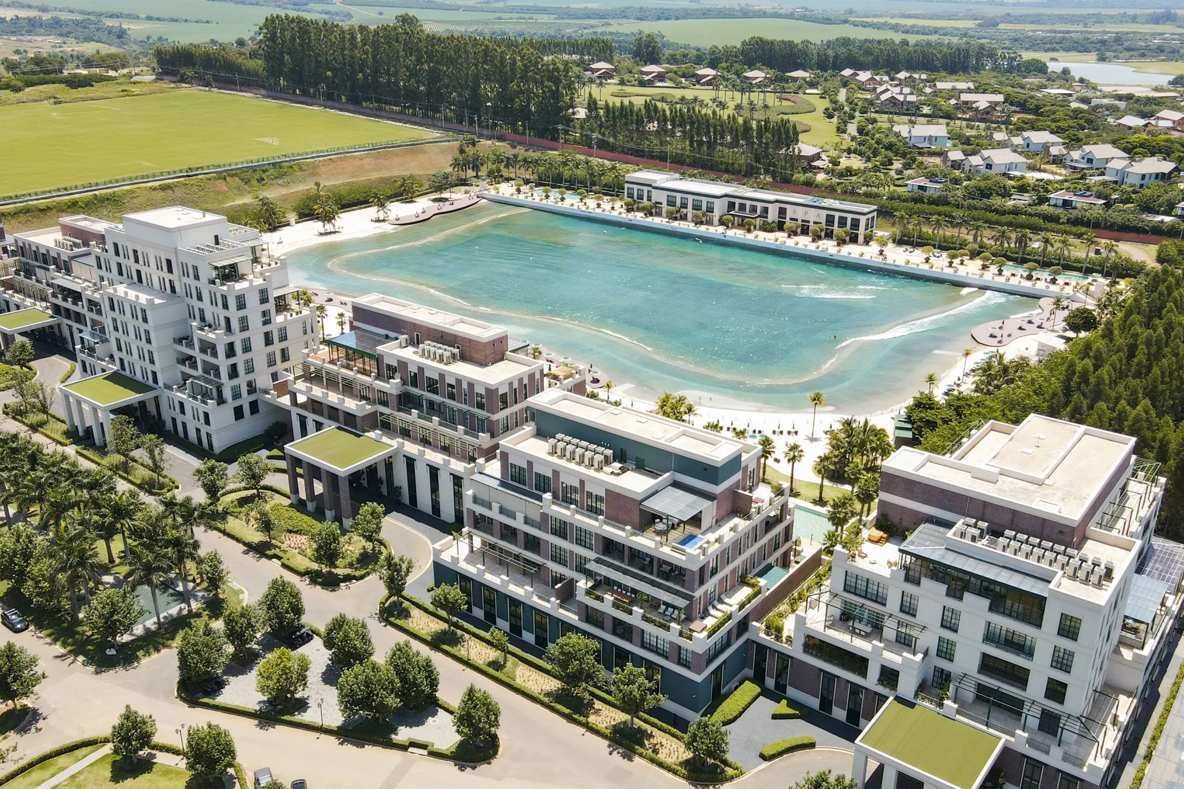 Vista aérea do Boa Vista Village: a piscina de ondas com a praia, cercada pelos edifícios residenciais e pelo gramado.