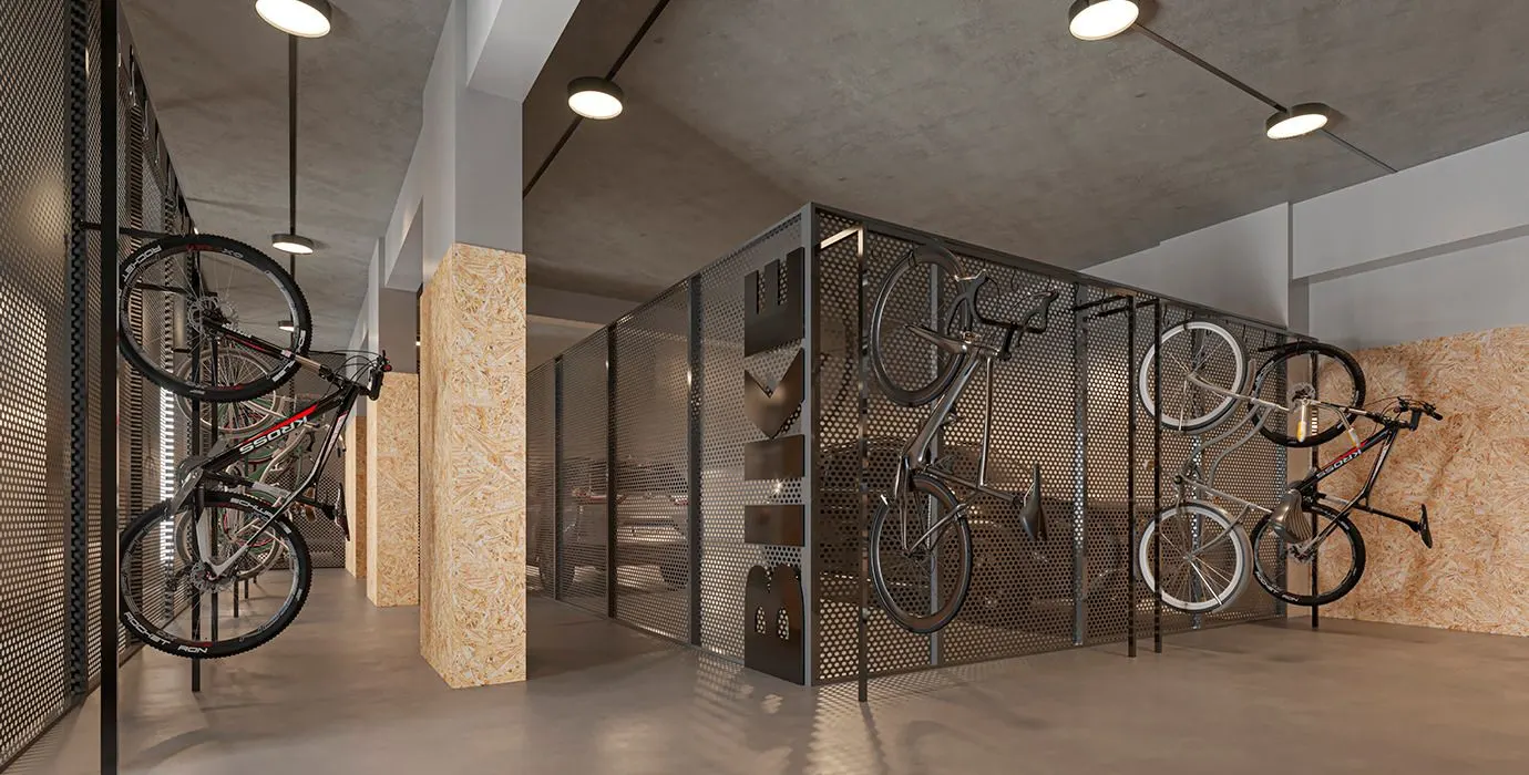 O bicicletário com bicicletas penduradas em suportes de parede, atrás de portas de vidro.