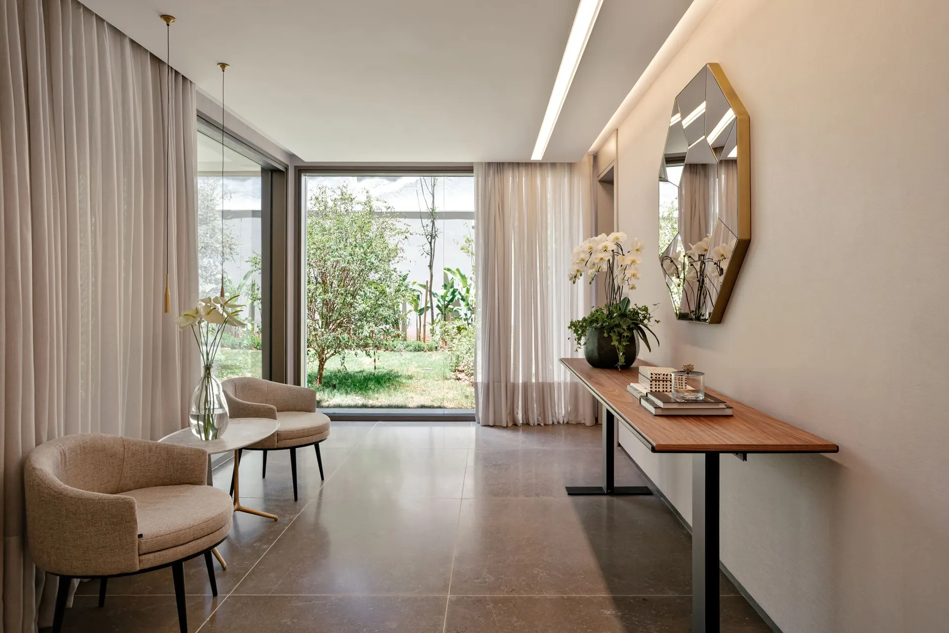 O espaço bem-estar, com poltronas, espelho e a porta de vidro aberta para o jardim.