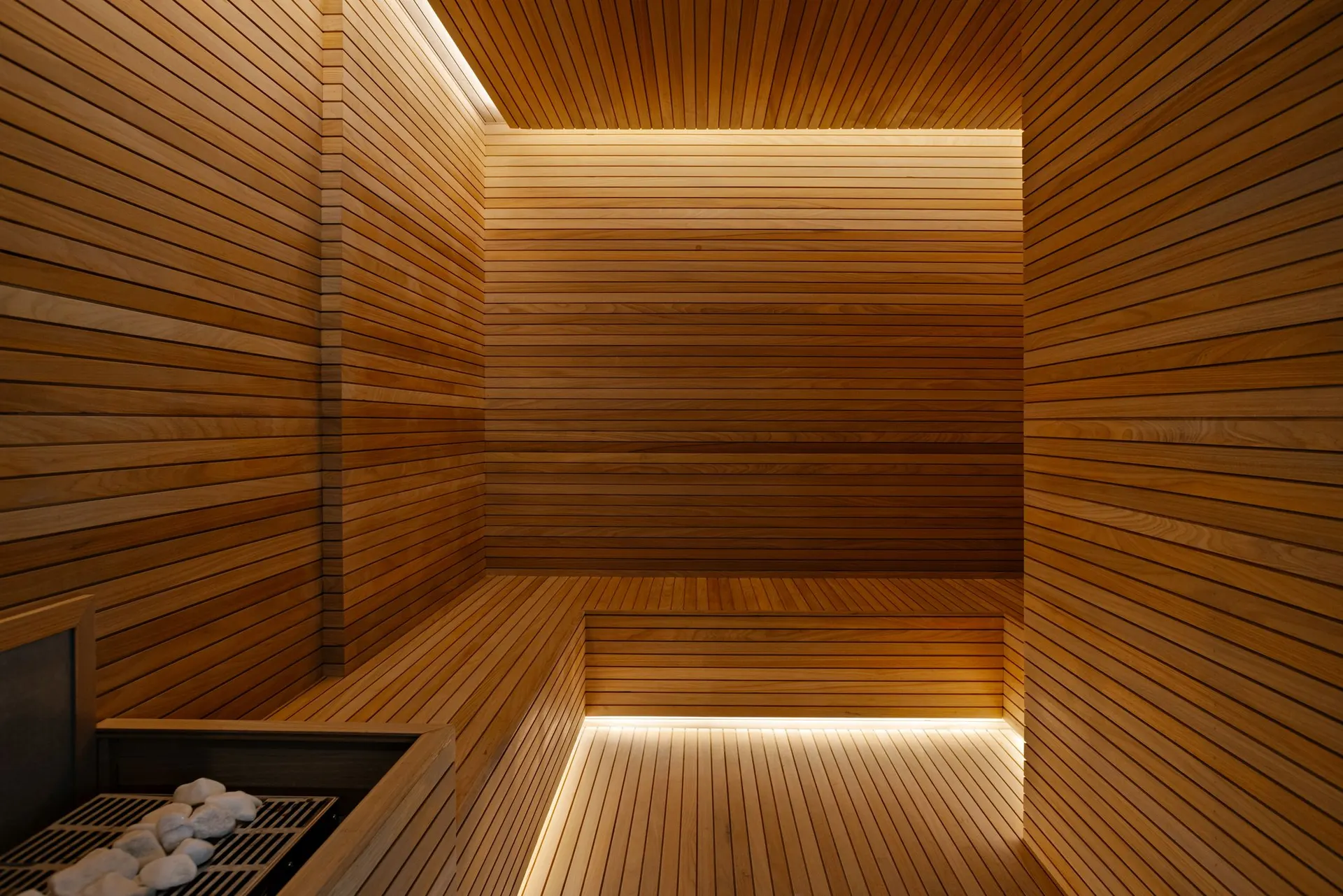 A sauna seca, toda em madeira, com a luz embutida no banco.