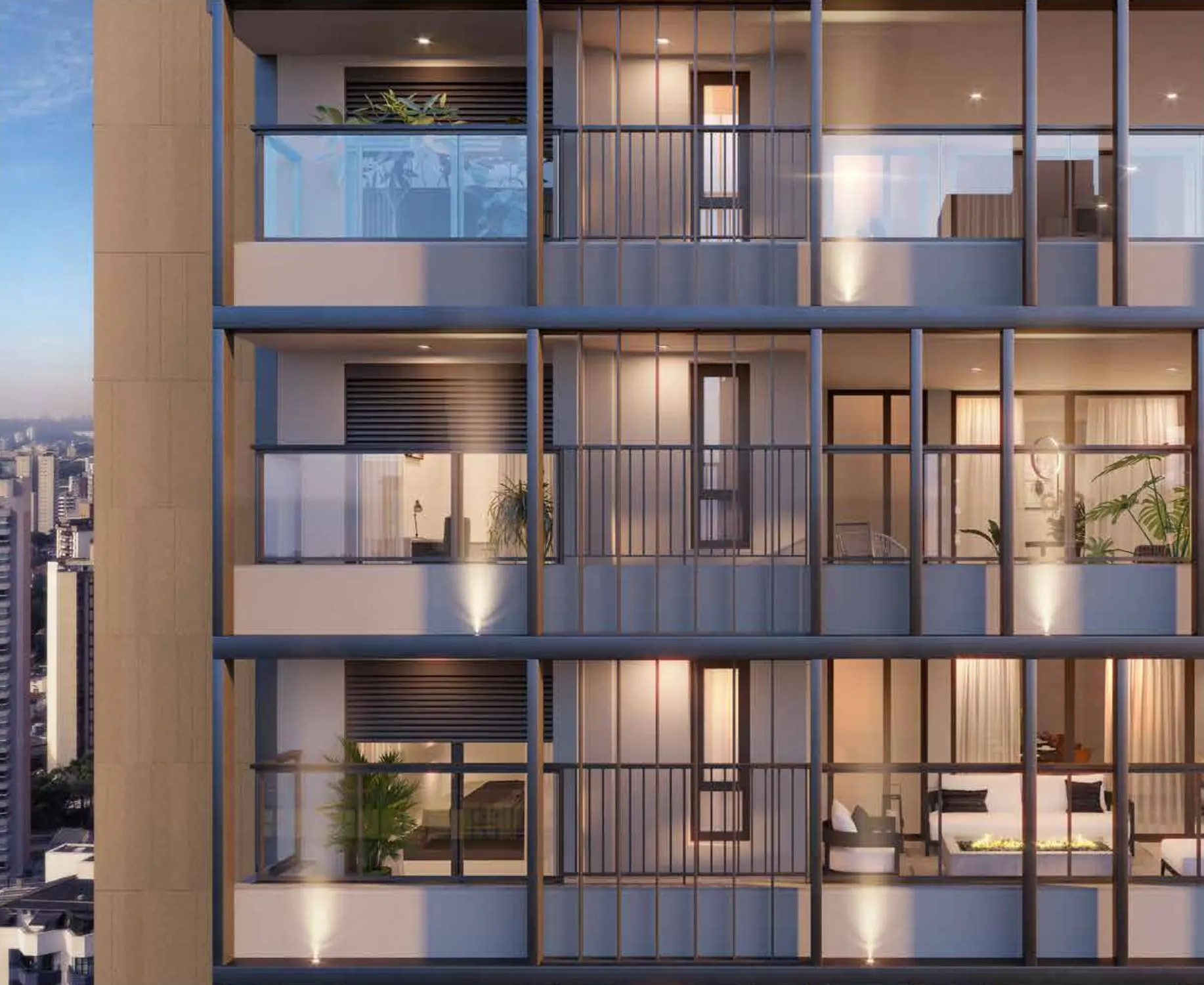 Detalhe da fachada: varandas de vidro e os perfis verticais do grid, com a luz acesa nos apartamentos.