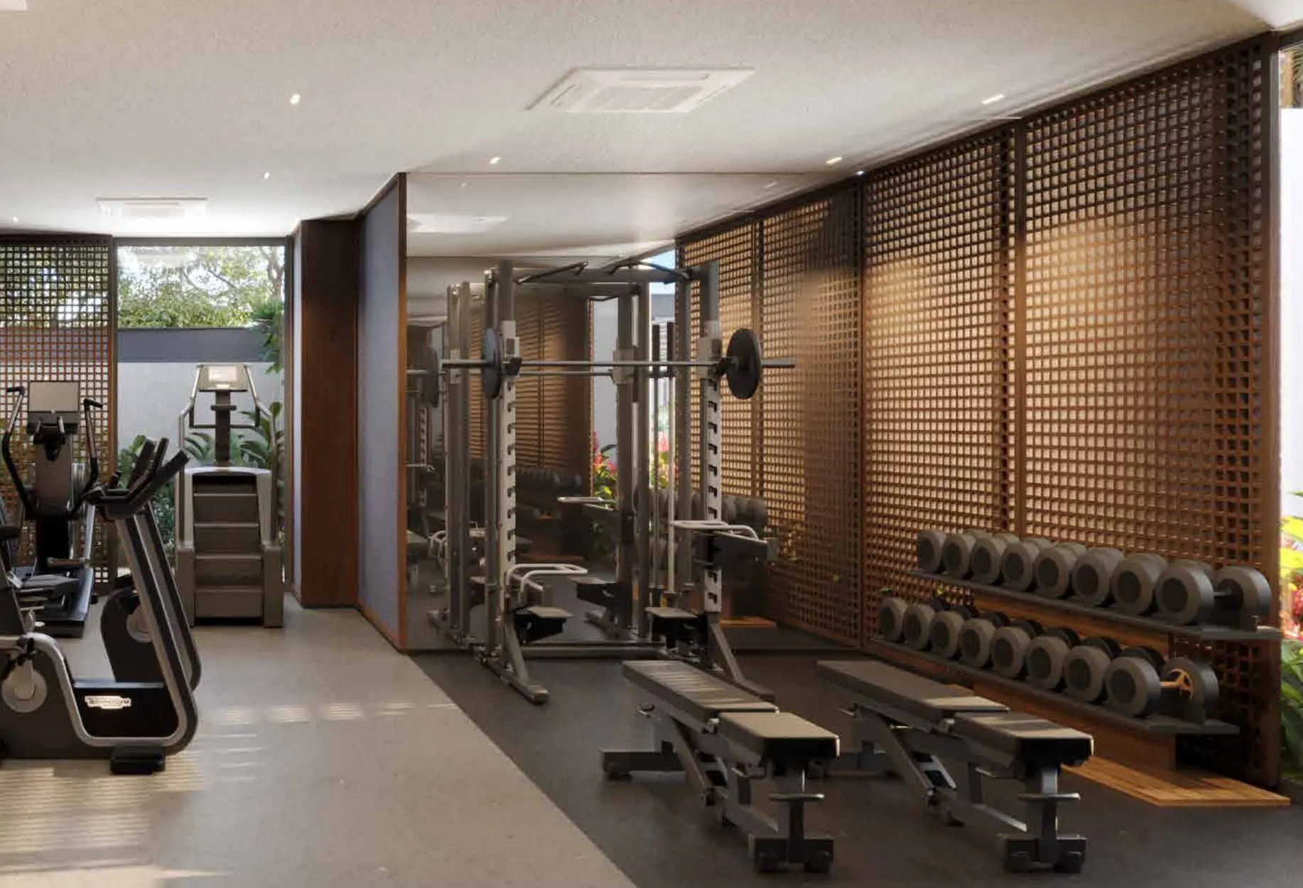 O fitness com aparelhos de musculação diante de uma parede de madeira ripada.