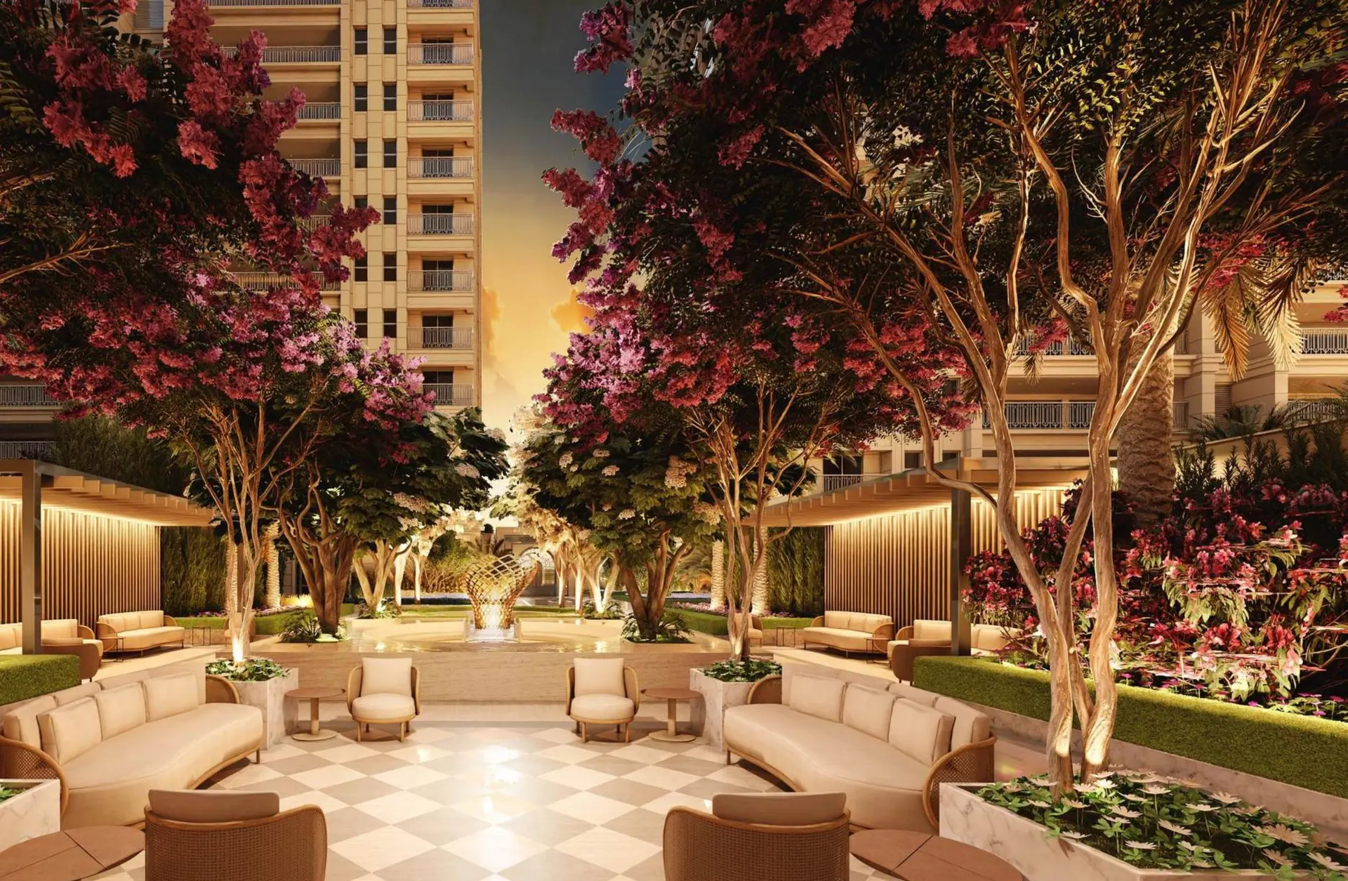 Um dos jardins do Harmonie ao anoitecer: sofás sob árvores floridas, piso em xadrez e luz baixa.