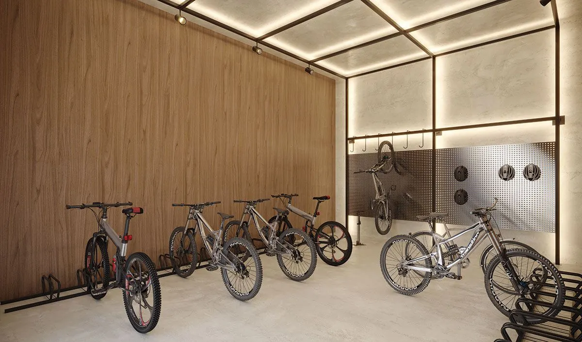 O bicicletário revestido de madeira, com bicicletas em suportes de parede e de piso.