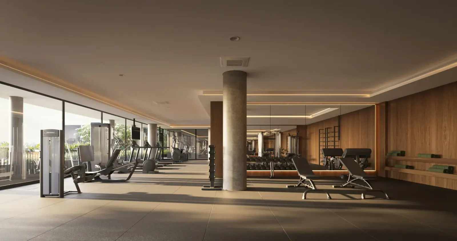 O fitness: esteiras e aparelhos em fila junto às janelas, um pilar redondo de concreto e o painel de madeira ao fundo.