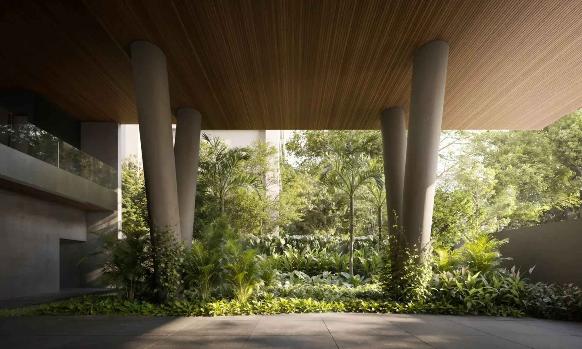 O hall aberto para o jardim: os pilares de concreto em V sob a laje, a vegetação densa e a escada ao fundo.
