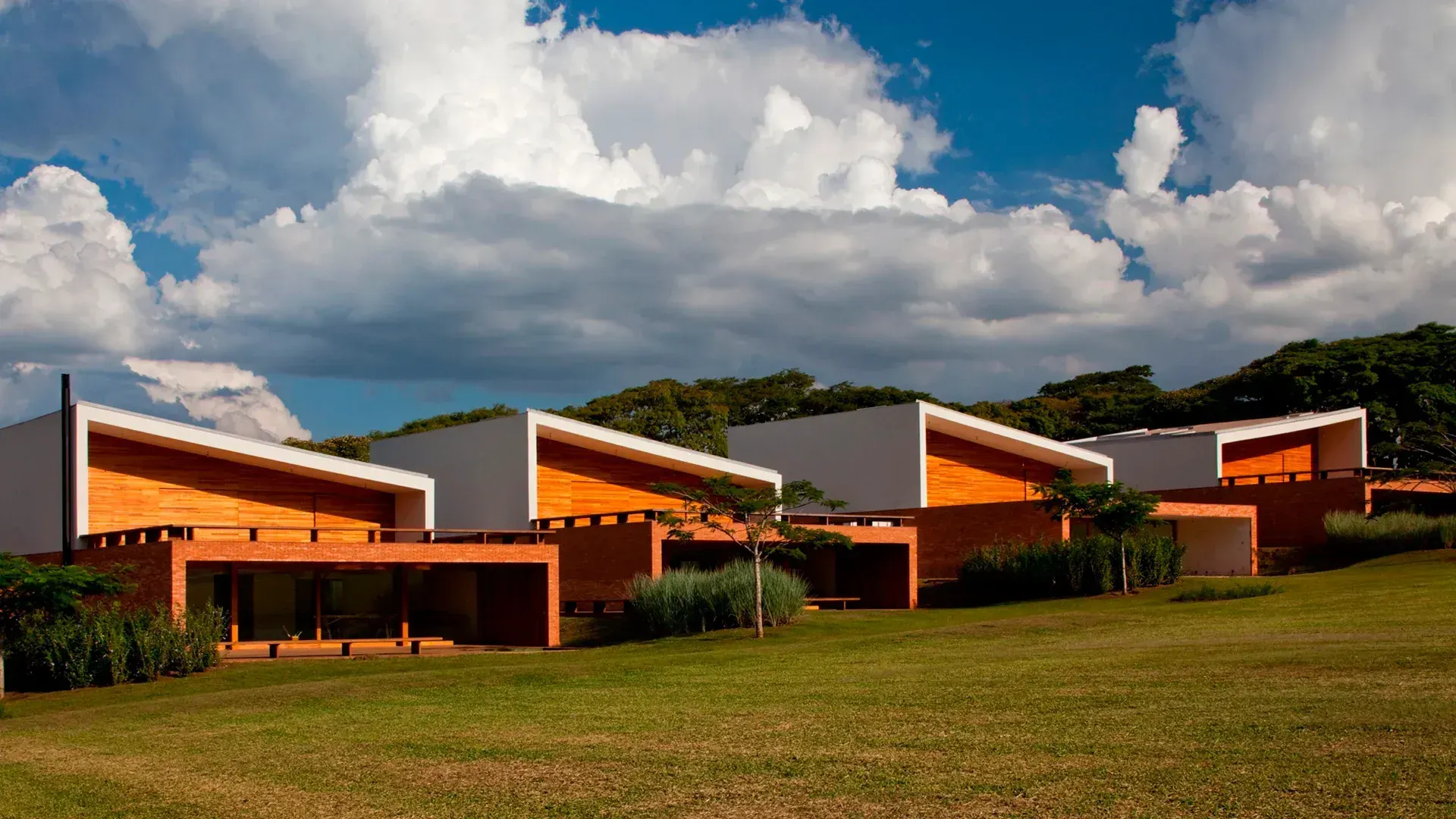 As Villas Fasano do Hotel, de Isay Weinfeld: volumes de tijolo e telhados inclinados sobre o gramado.