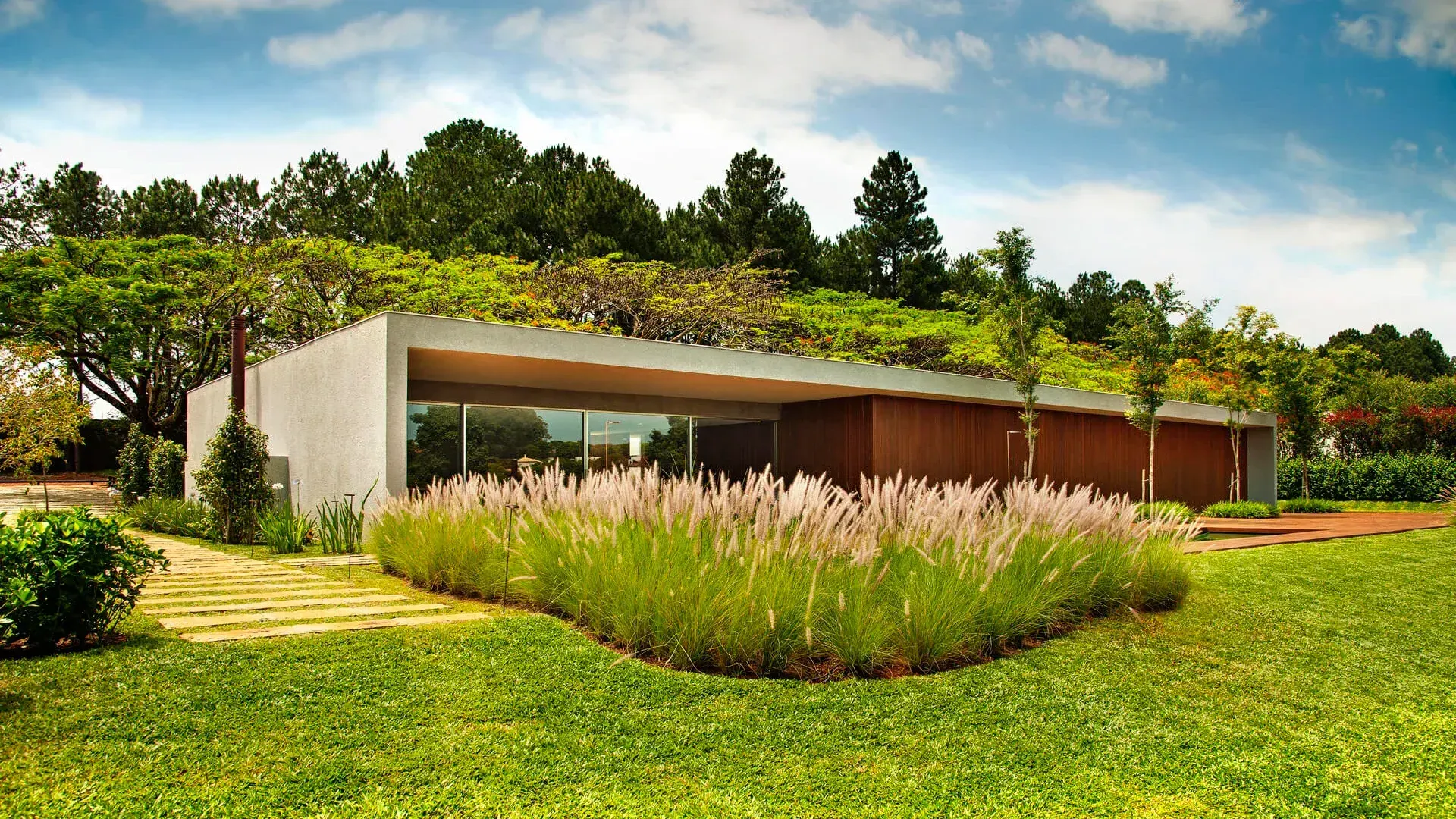 As Villas Fasano do Tênis, de Marcio Kogan: cobertura verde e fachada de vidro diante do gramado.