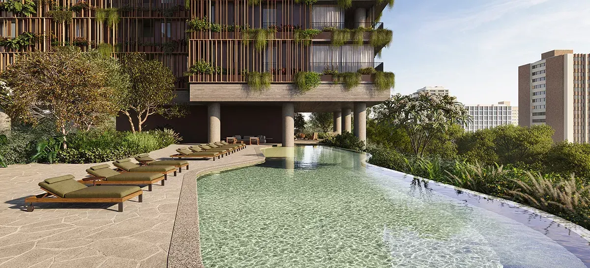 A piscina externa de borda curva e água verde-clara, com espreguiçadeiras na pedra, o jardim em volta e a torre com jardineiras ao fundo.