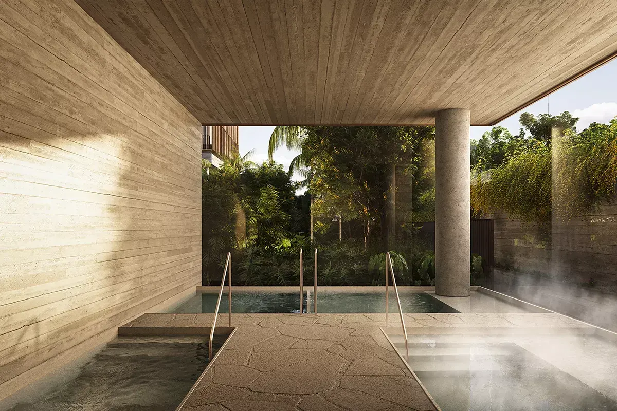 O spa: a parede de pedra clara, o forro de madeira e uma piscina aquecida com vapor, aberta para o jardim.
