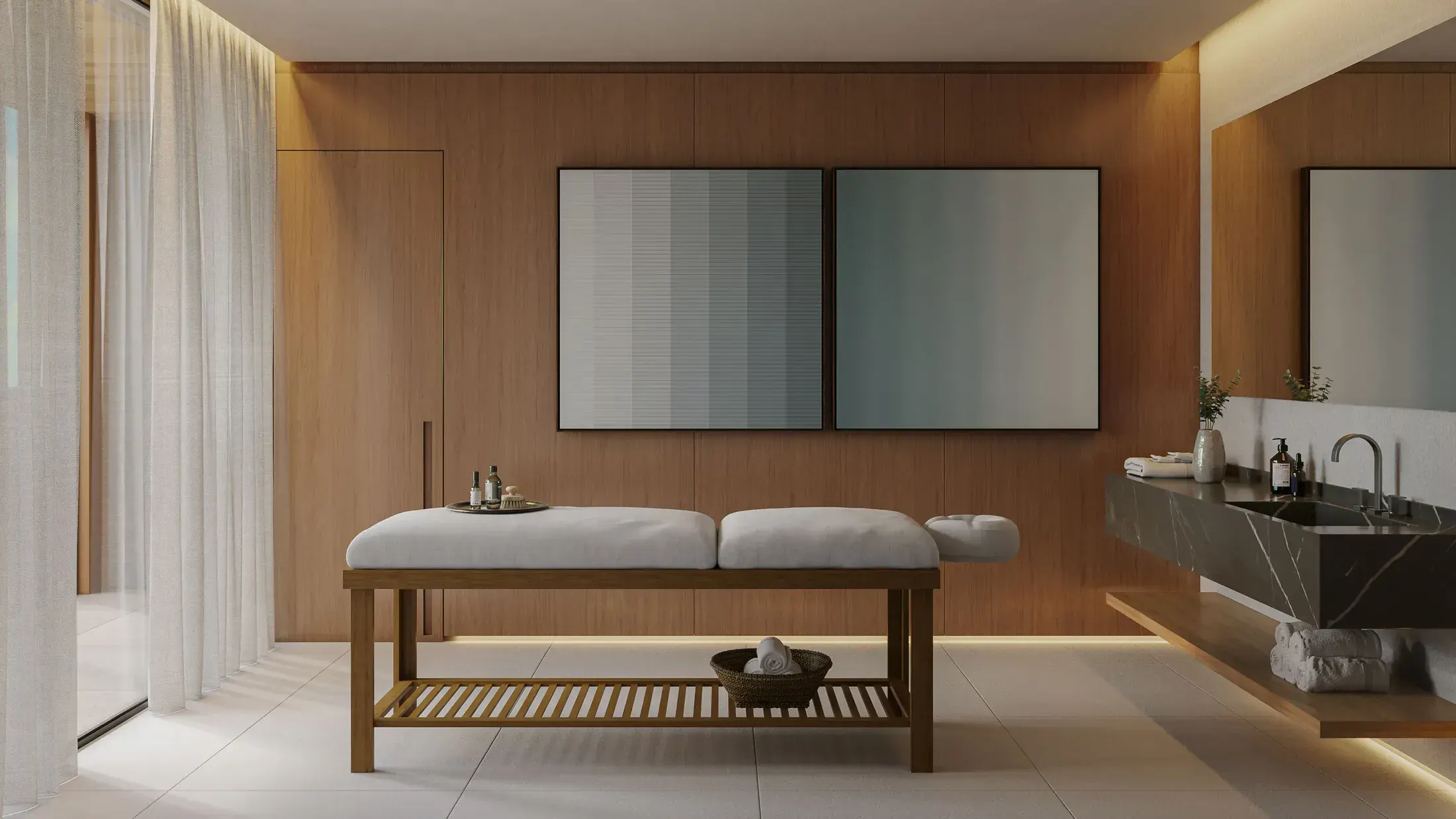 A sala de massagem: a maca de madeira, os painéis de madeira na parede, a cortina clara e a bancada de pedra escura.