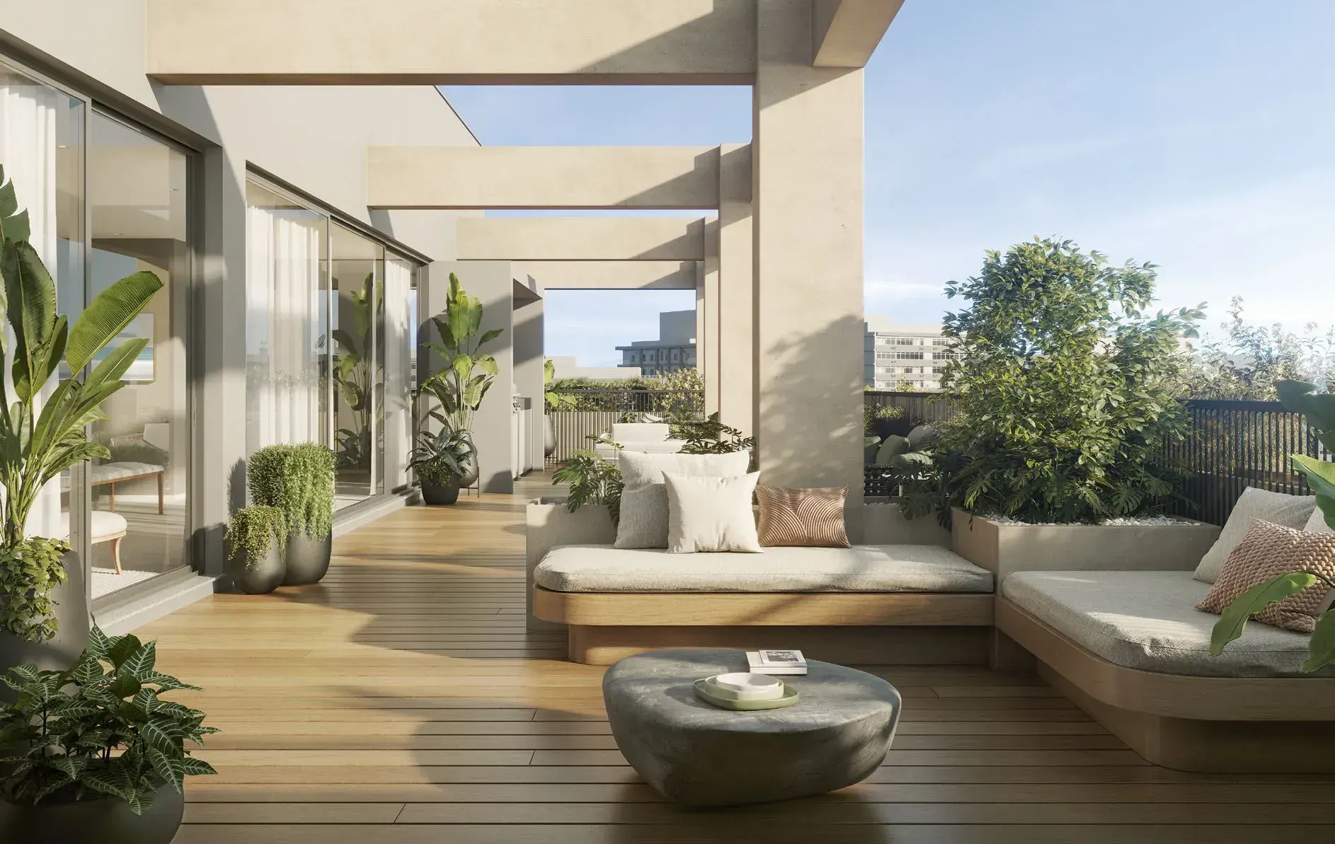 O terraço gourmet da cobertura duplex: o estar com sofás claros sobre o deck de madeira, as plantas em vasos e o céu aberto sobre a pérgola.