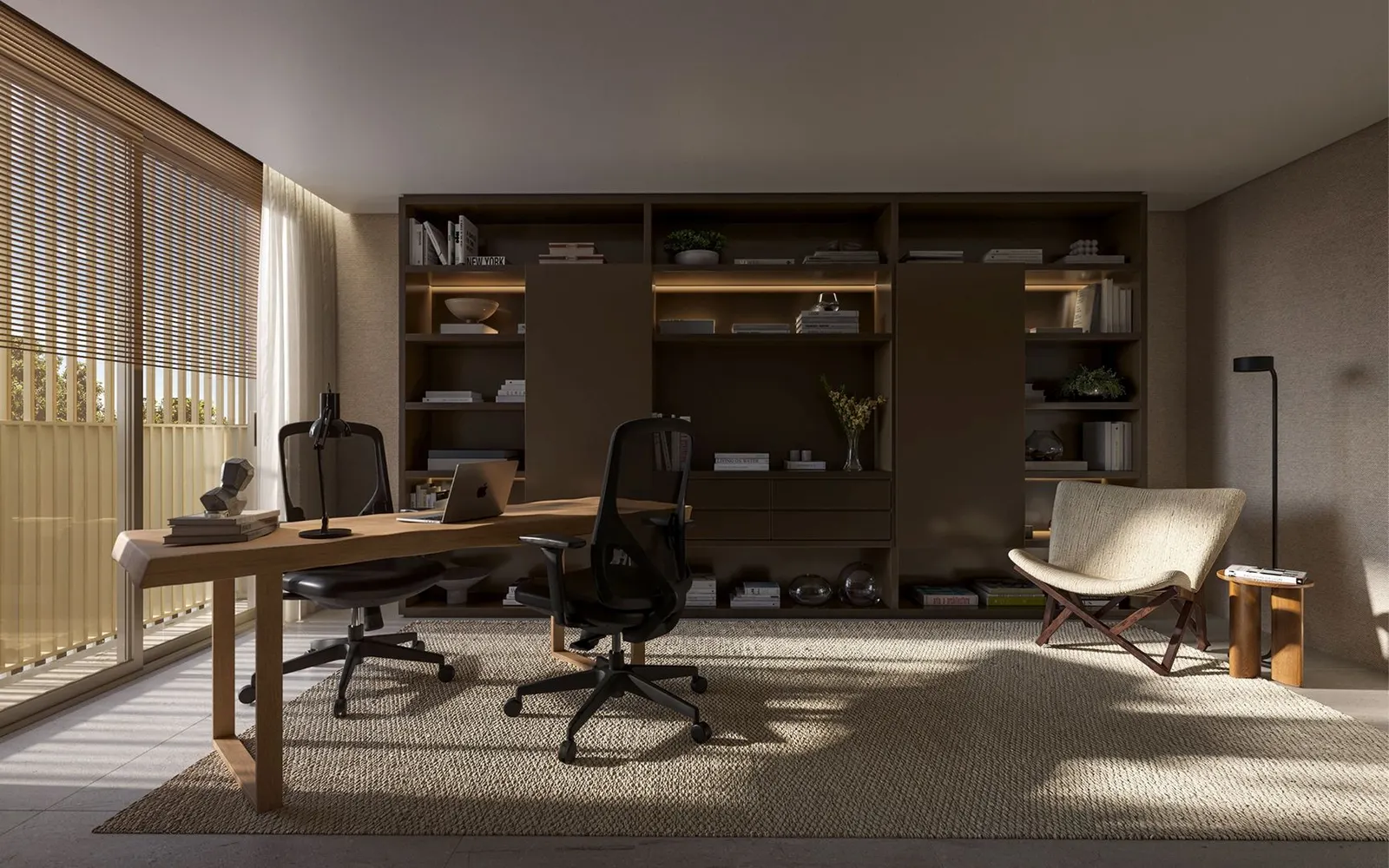 O office com uma mesa de madeira, cadeiras de escritório, estantes e uma poltrona de leitura junto à janela.