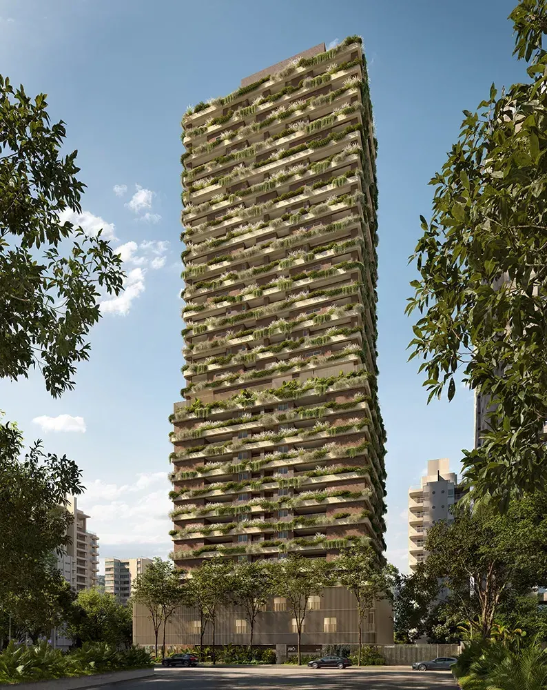 A torre vista da calçada, de baixo para cima: as varandas cobertas de plantas até o topo, contra o céu azul.