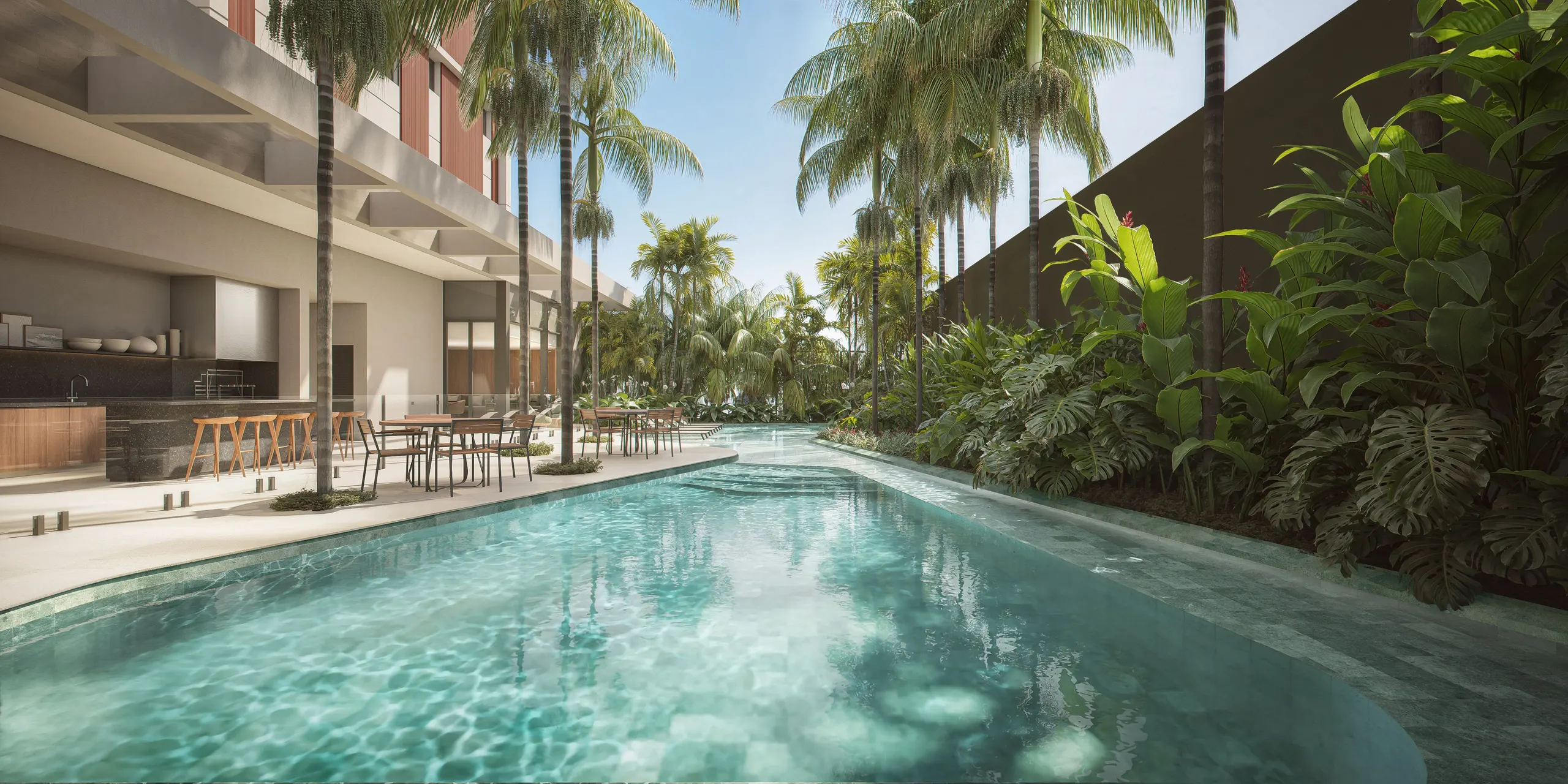A piscina descoberta ao lado da torre, entre palmeiras e plantas tropicais, com o deque de madeira e o bar à sombra.