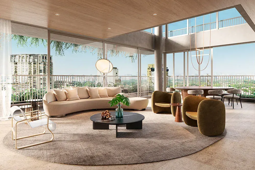 O living da cobertura triplex: o sofá curvo e as poltronas sobre um tapete redondo, o pé-direito alto e a varanda envidraçada com a vista do bairro.