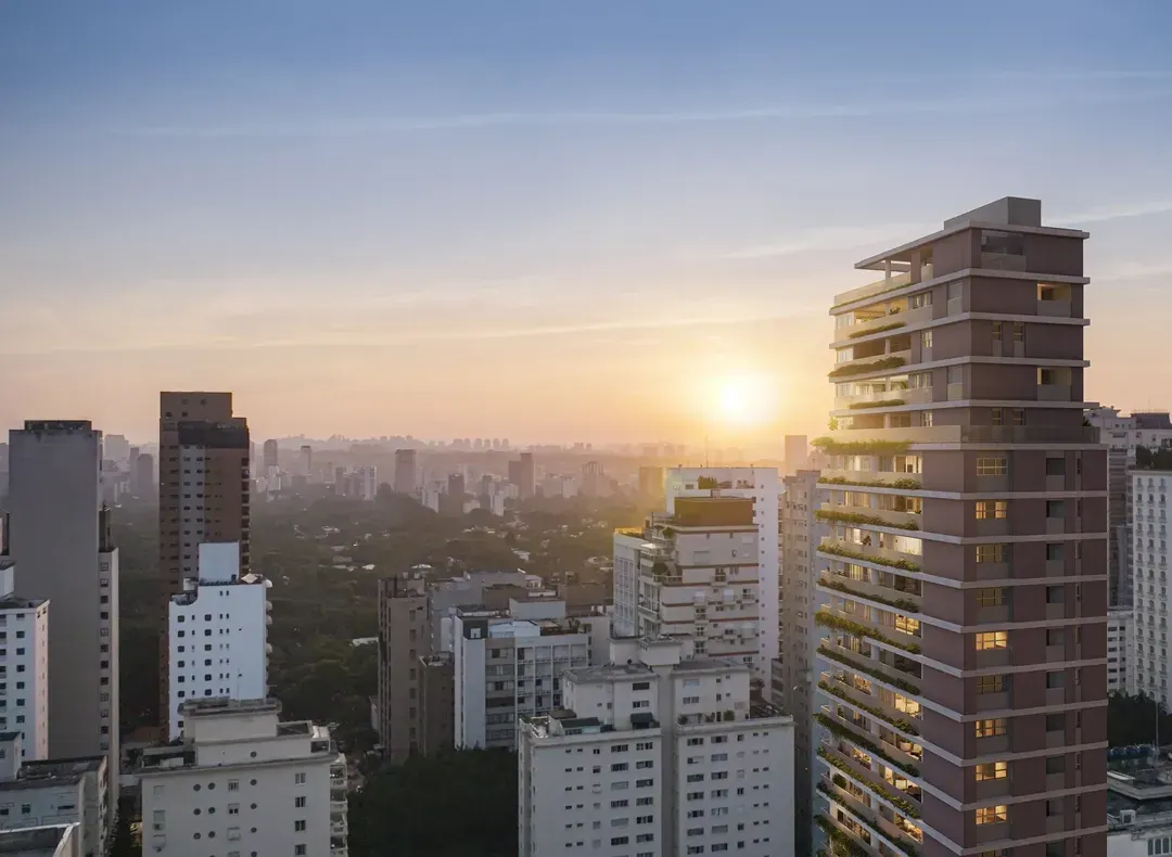 A torre do Oscar 900 ao pôr do sol, com as varandas escalonadas no alto, os prédios do bairro em volta e o sol baixo atrás, entre a névoa e as copas das árvores.