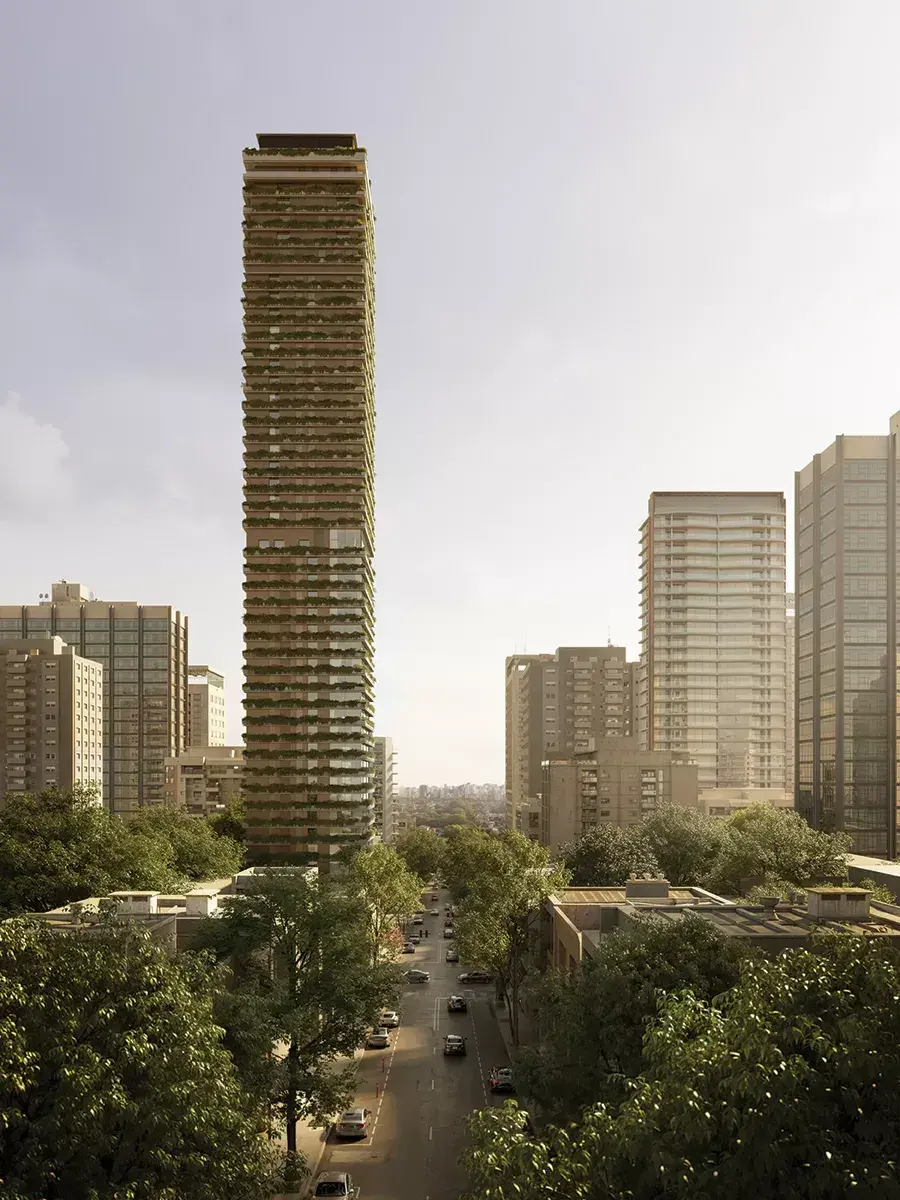 A torre do Plenitude vista de longe, de dia: alta e fina entre os prédios da rua, com jardineiras em todos os andares, o céu claro em volta e a rua arborizada embaixo.