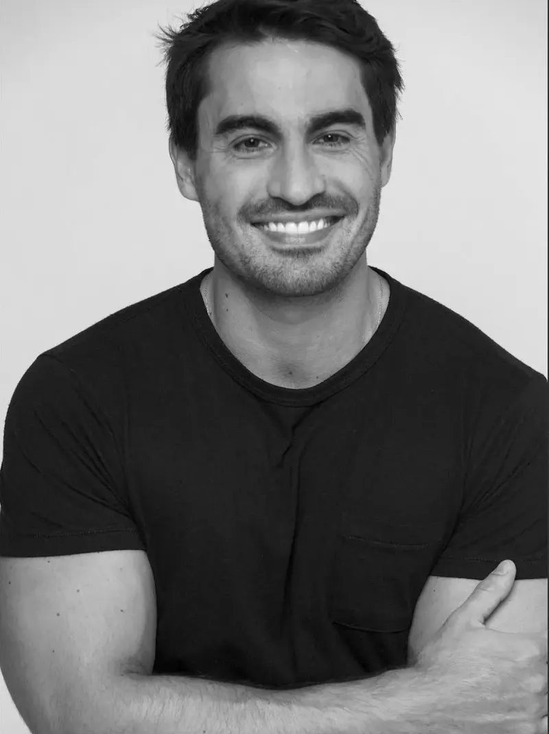 Vicente Montano, de camiseta preta e braços cruzados, sorrindo, em fotografia em preto e branco.