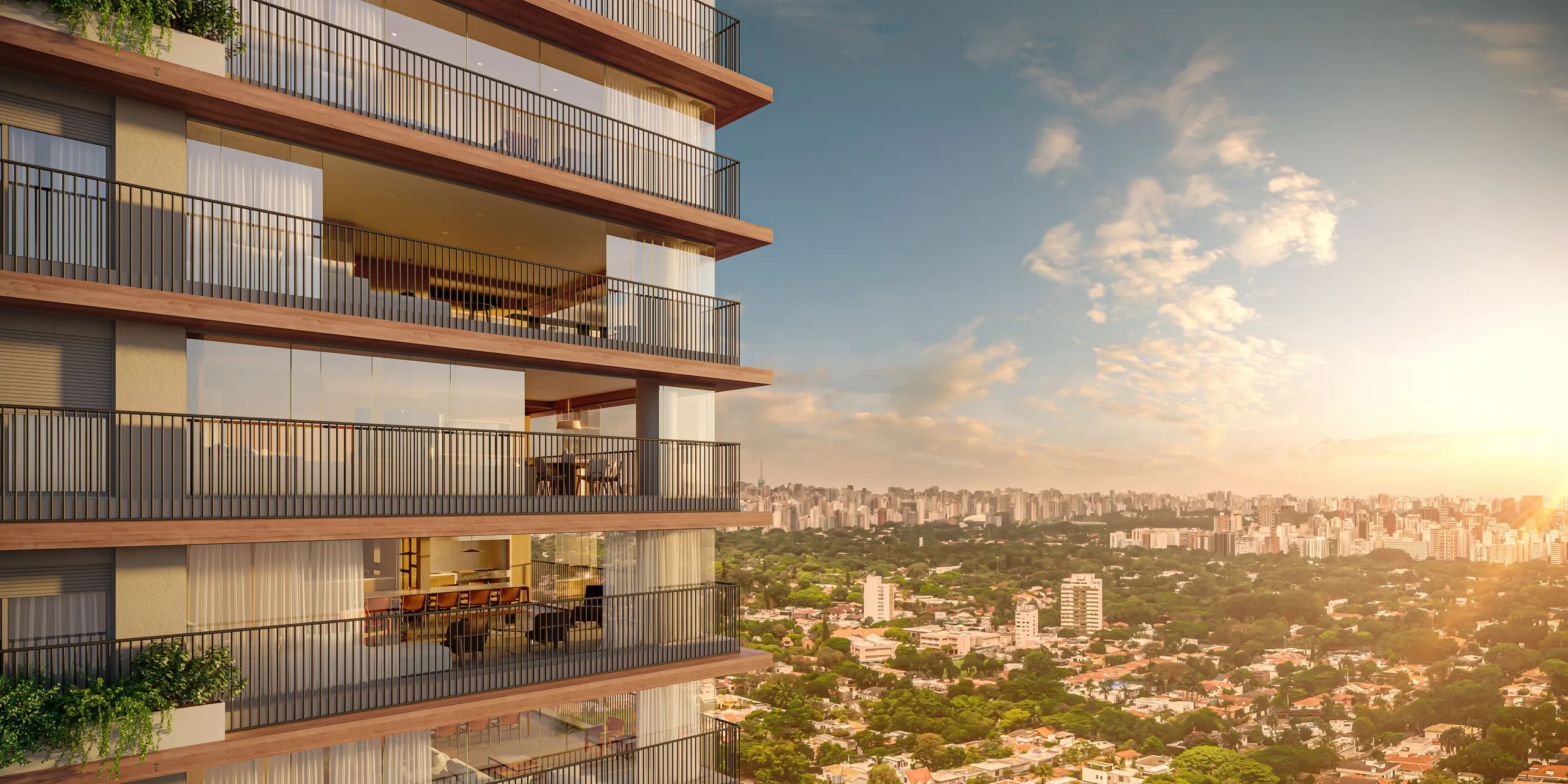 As varandas da torre ao pôr do sol, com floreiras e caixilhos de piso a teto, sobre o verde dos Jardins e a cidade ao fundo.